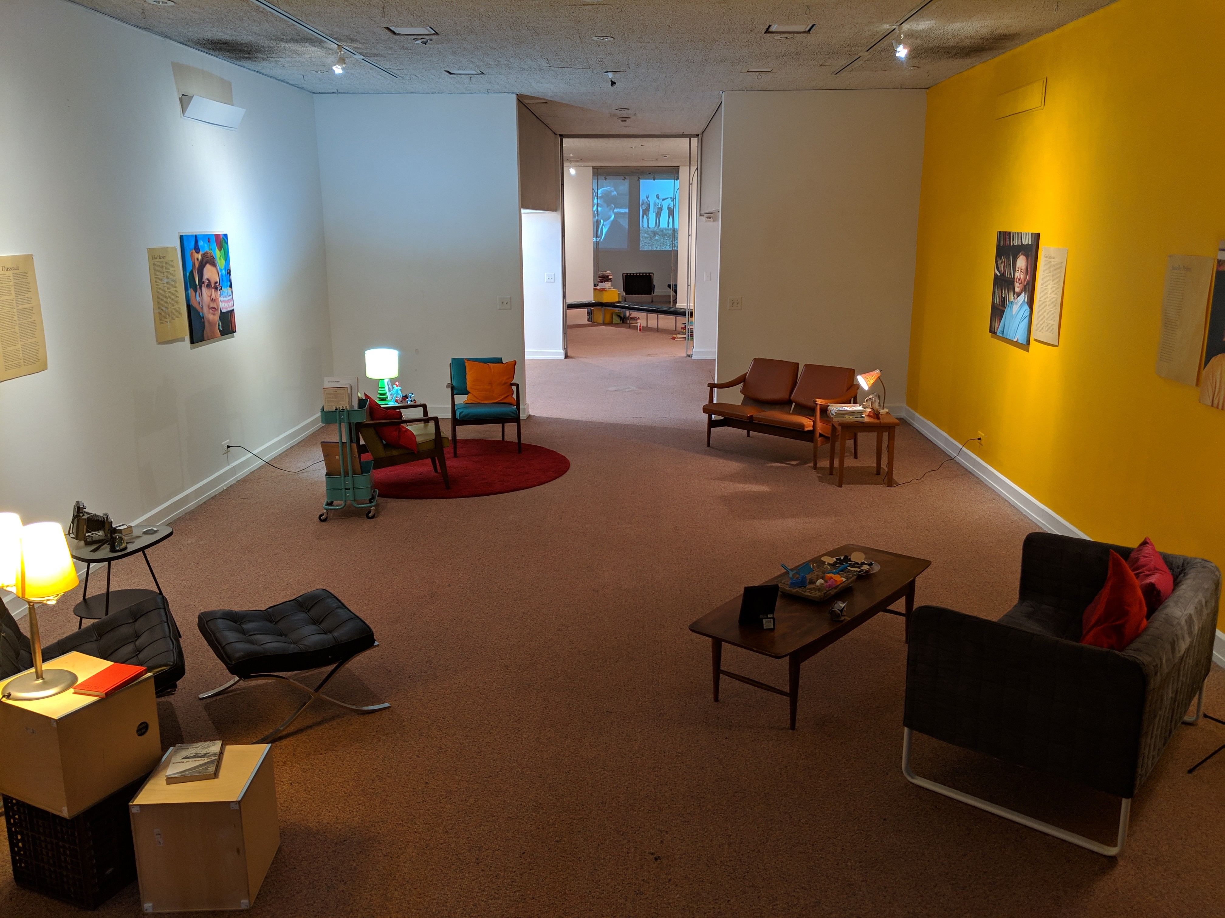 low lit room of four seating areas-- each representing a professor.